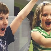 kids smiling at computer because when technology companies compete, community wins
