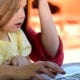 child on parents lap using laptop for cybersecurity awareness