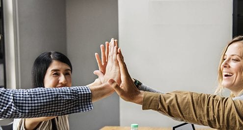 employees smiling and high-fiving to show engagement