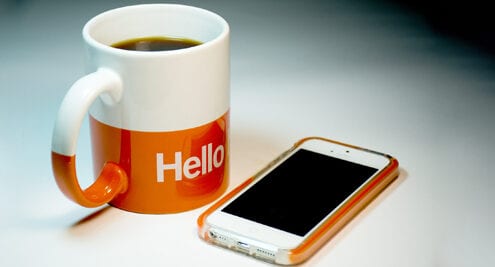 coffee cup and phone saying hello to new team members