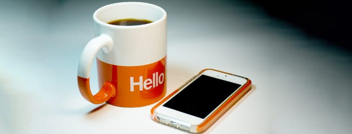 coffee cup and phone saying hello to new team members
