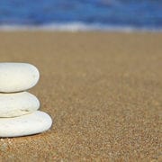 3 rocks balancing on a beach to show work life balance