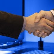 handshake through computer welcoming new team members